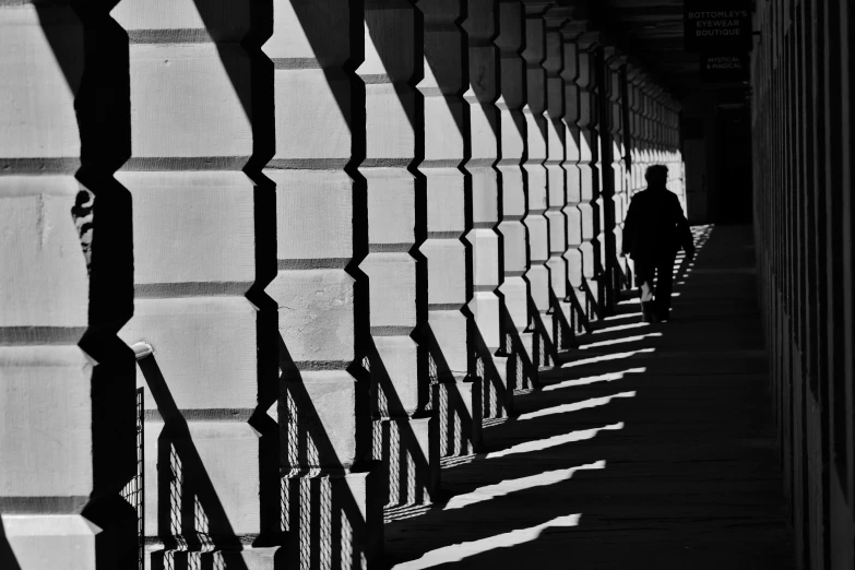 a person walking down a hallway between two rows of tall building