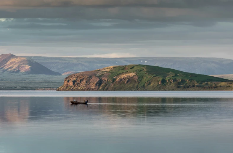 a small boat sits in the water near mountains