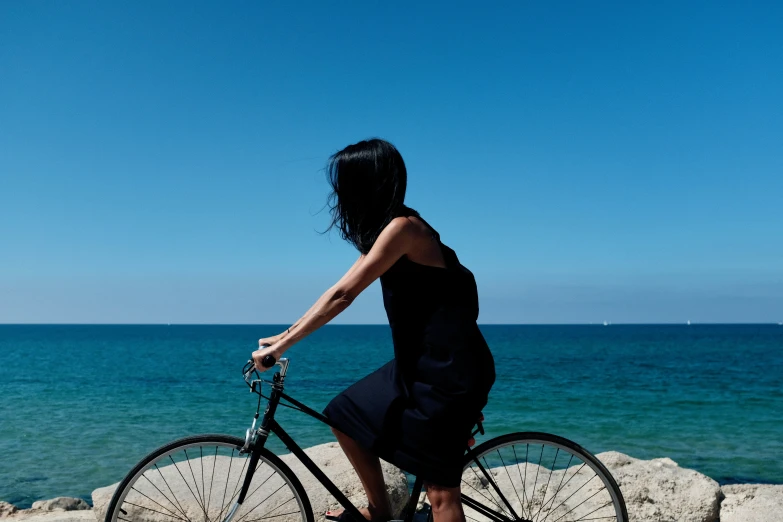 woman riding a bicycle near a water feature