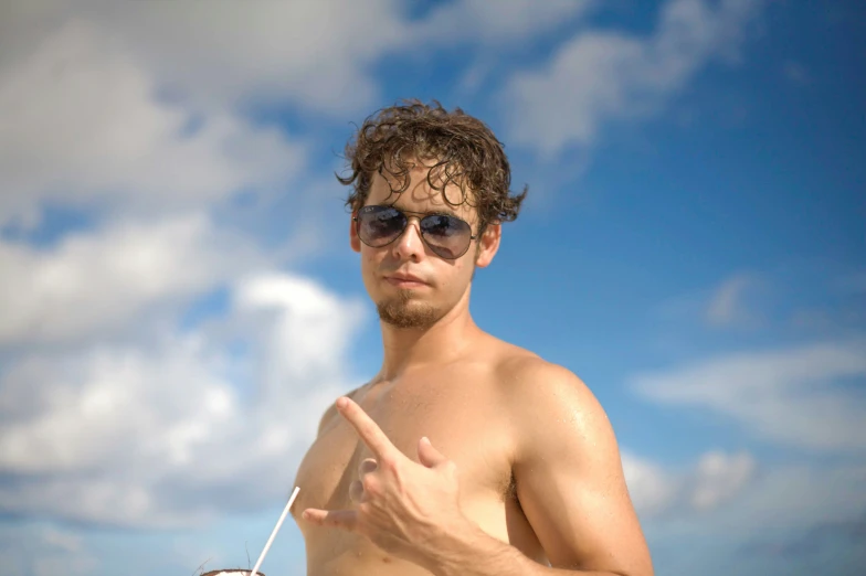 a shirtless young man is holding a straw and pointing