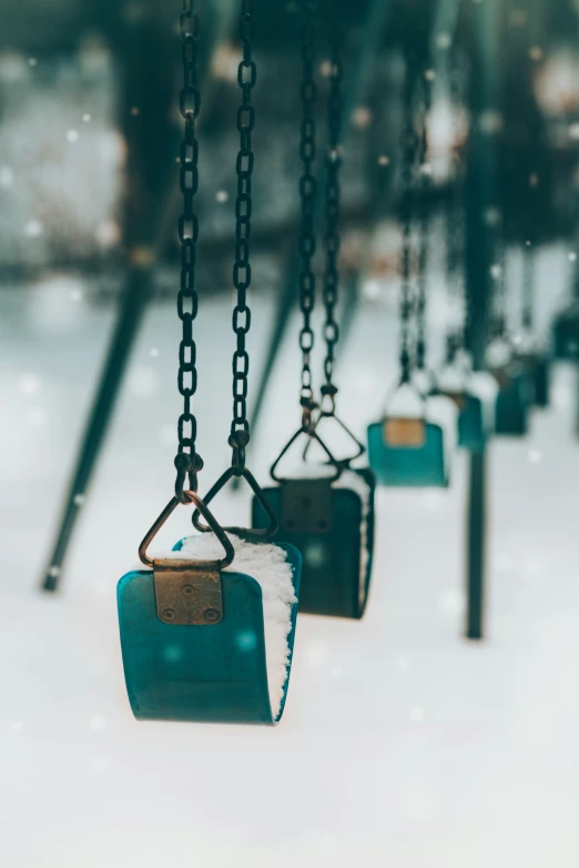 swings that have snow falling down on them