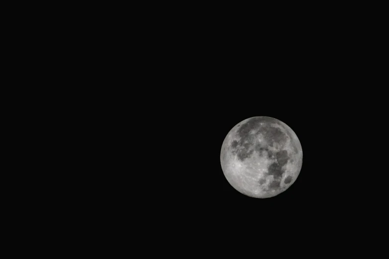 a small airplane flying in front of the moon