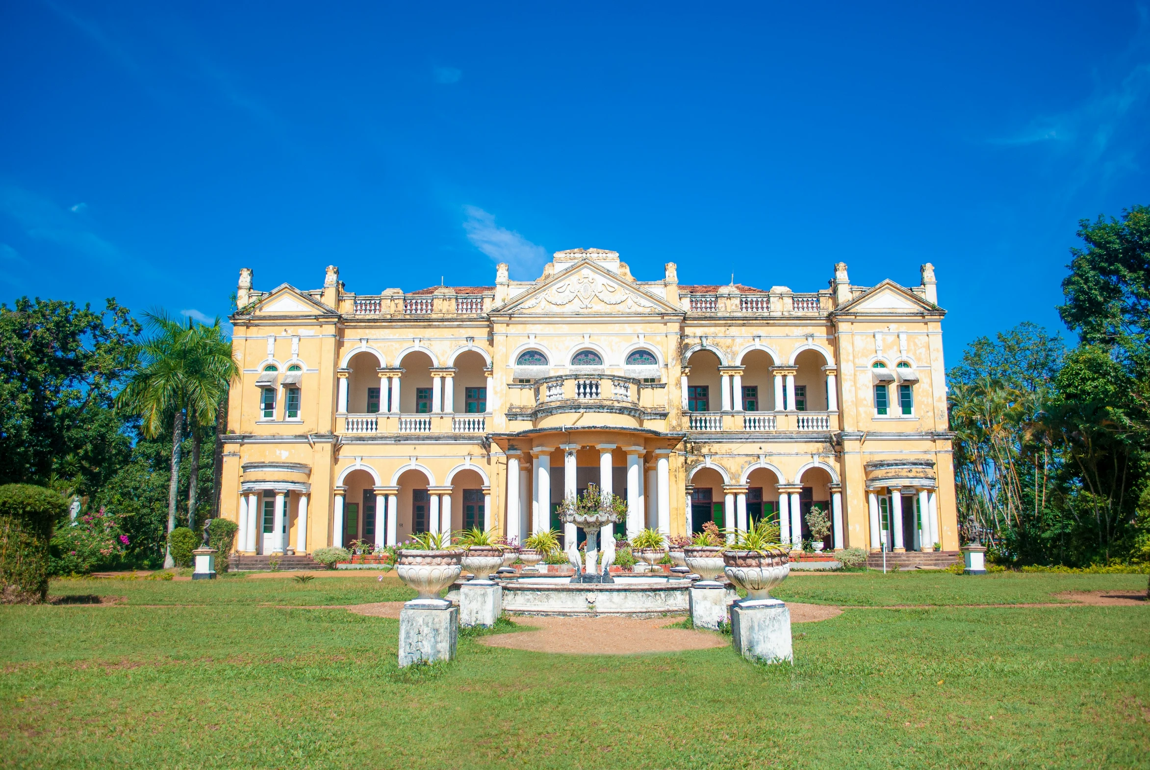 the front of a building with a fountain in the yard