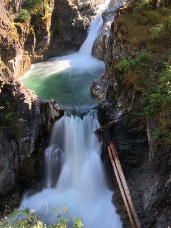 large waterfall in front of a rocky hillside with water