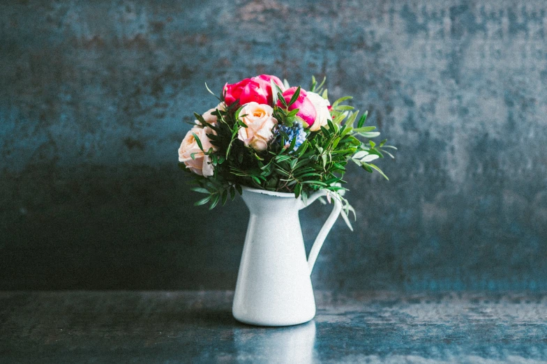 a vase is holding many different flowers on a counter