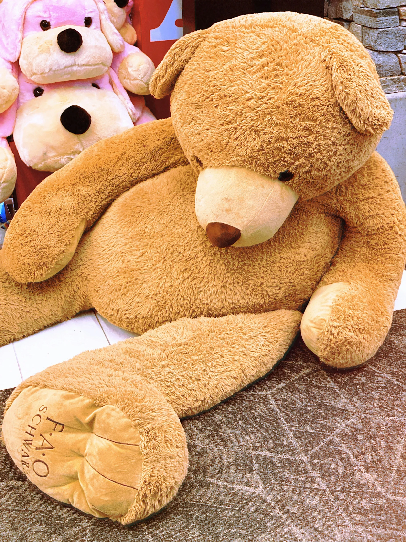 two large brown teddy bears on top of a floor