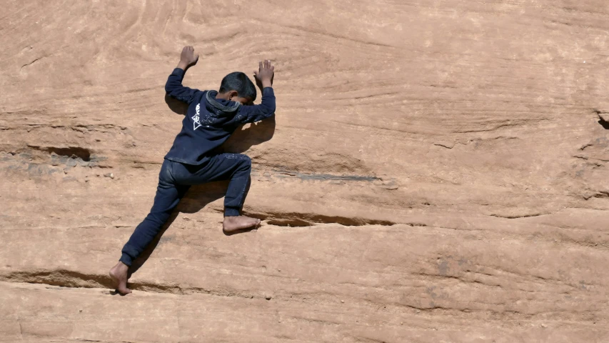 a man jumping off of the side of a mountain