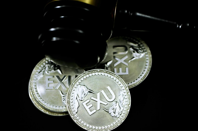 a wooden judges hammer and two silver canadian dollars