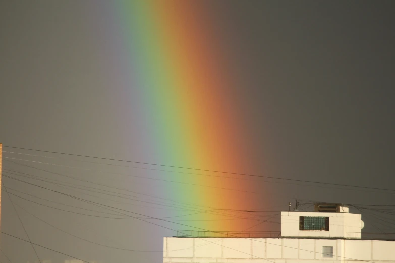 the sky with a rainbow near some power lines