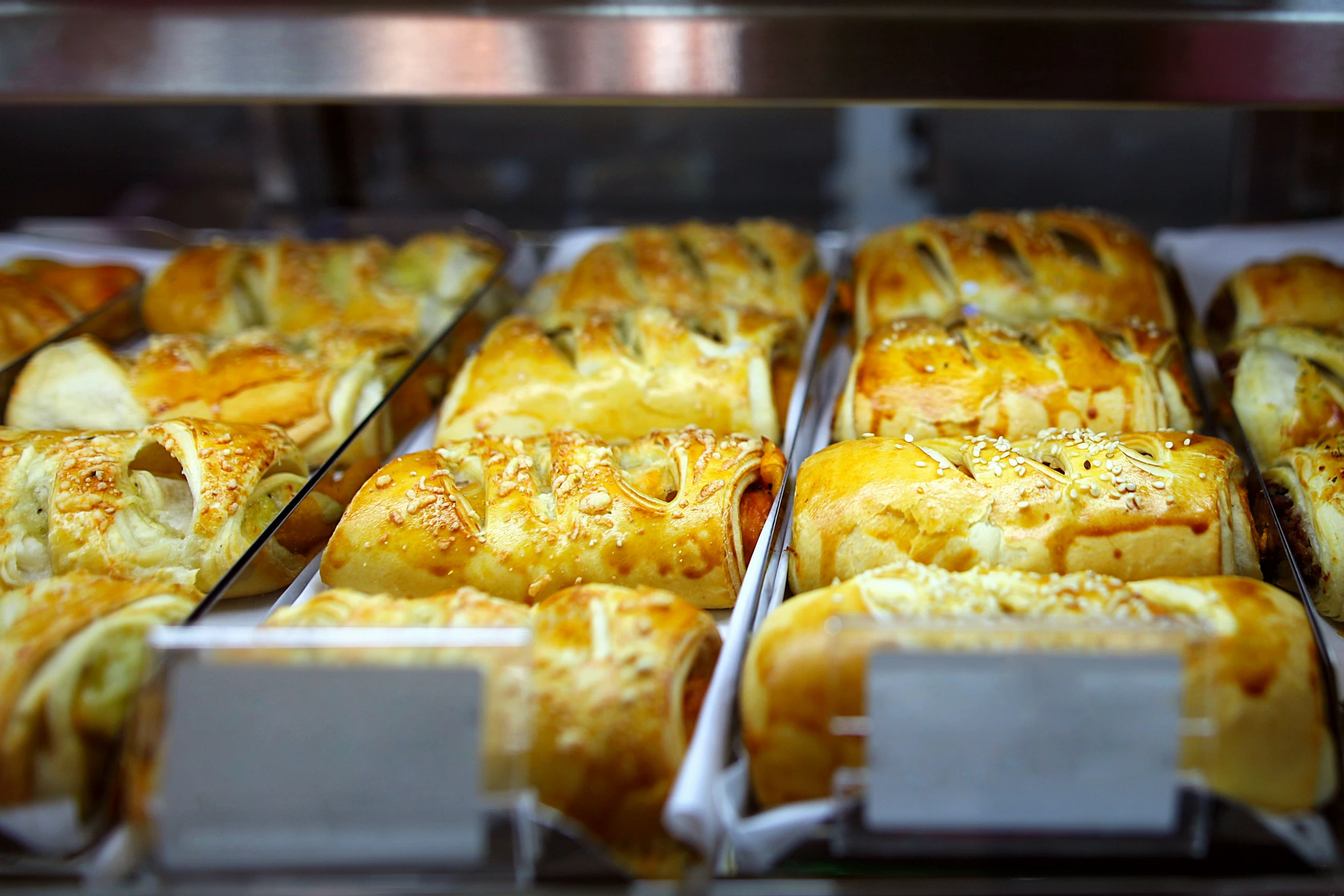 many different pastries displayed in rows on shelves