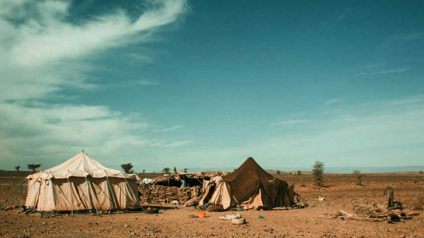 a tent and a few people in the dirt