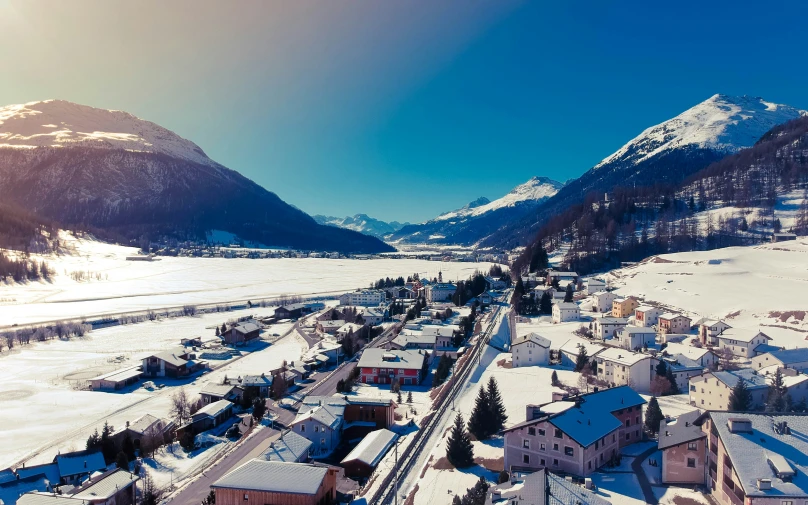 a small town is surrounded by snow and mountains