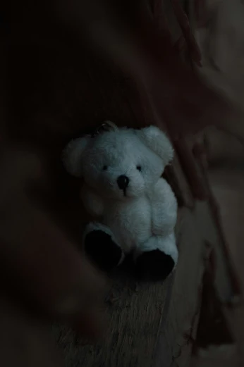 a teddy bear sitting alone in the dark