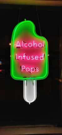 a neon sign has a heart and the words alcohol is infused pops