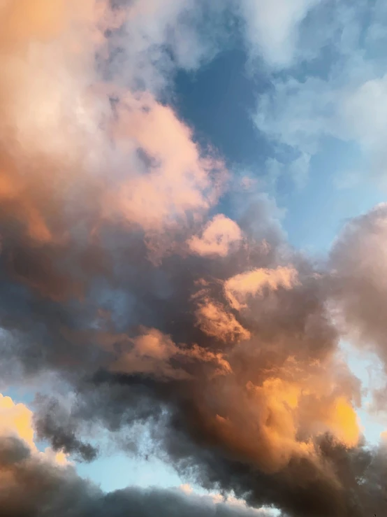 some clouds and an airplane are in the sky