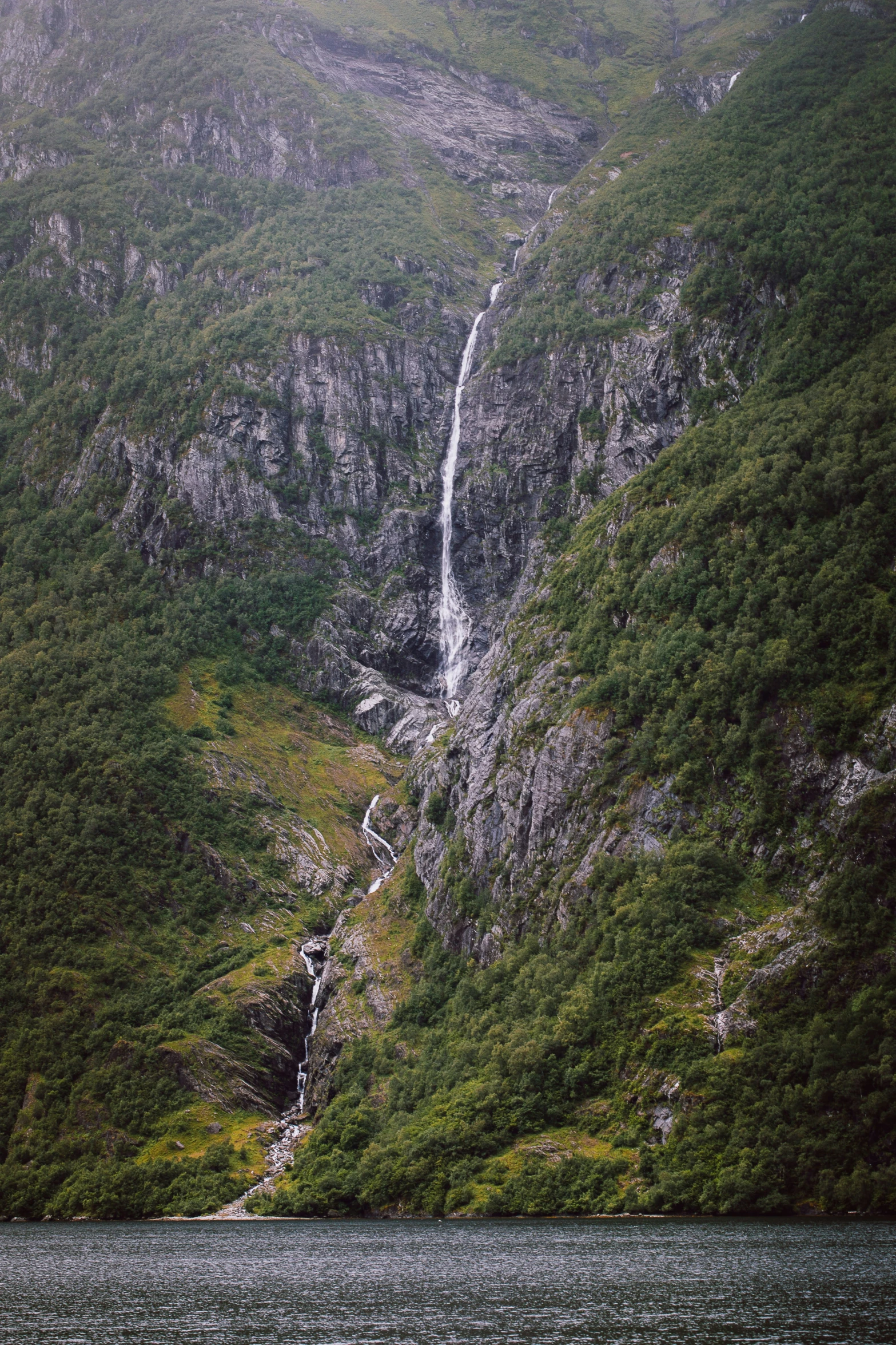 a scenic view of a very tall waterfall