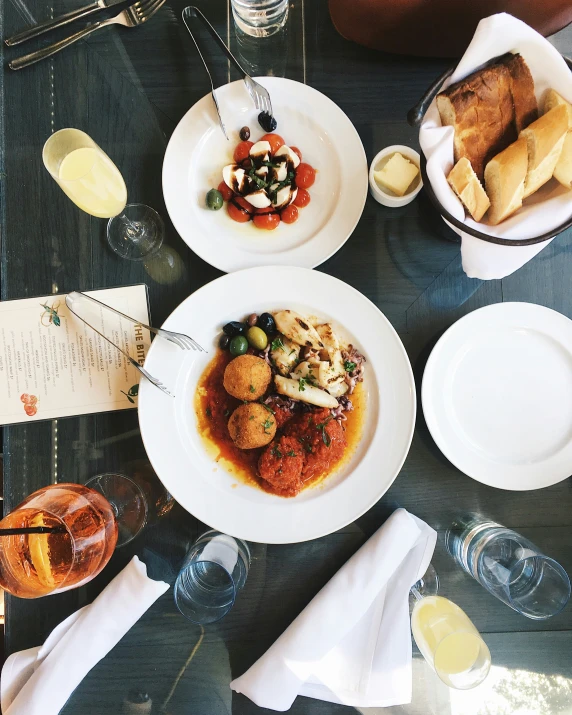 a group of plates of food sitting on top of a table