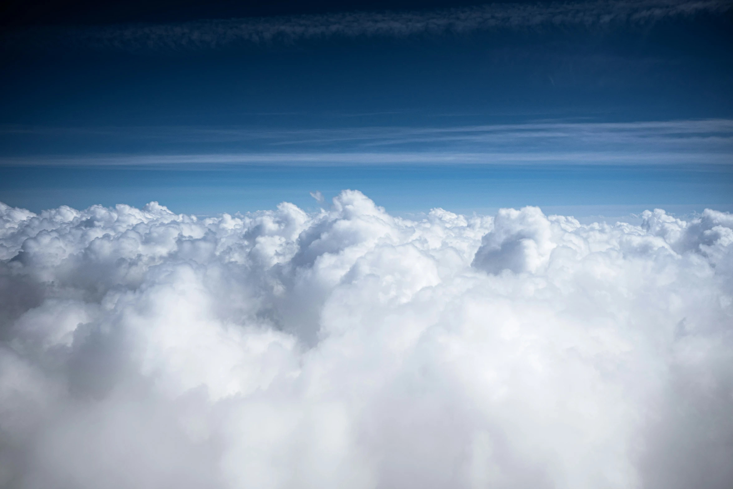 a plane flies above the clouds as it floats overhead