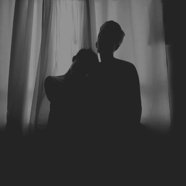 silhouette of a man and woman in front of a window