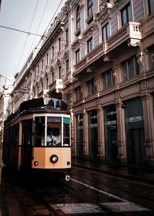 an old trolley is on the tracks in front of a building