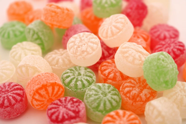 an assortment of brightly colored candy candies on white surface