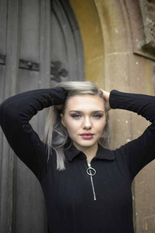 a young lady posing with her hair in pigtails and a long black dress