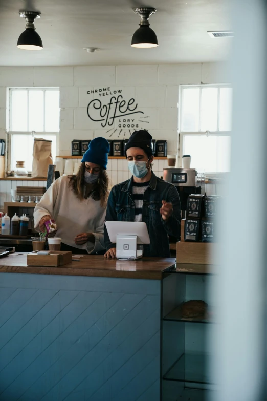 a man and woman sitting in front of a counter