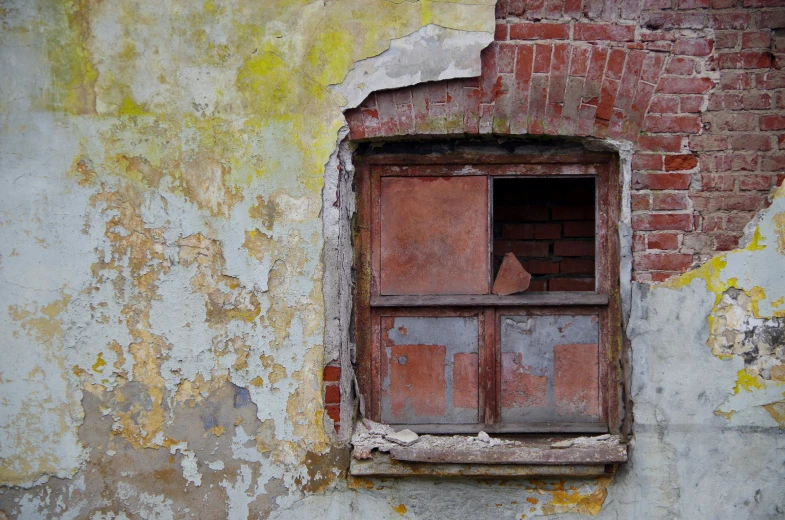 a window in an old building shows rust