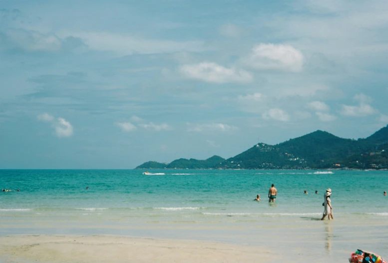 several people at the beach looking at the water