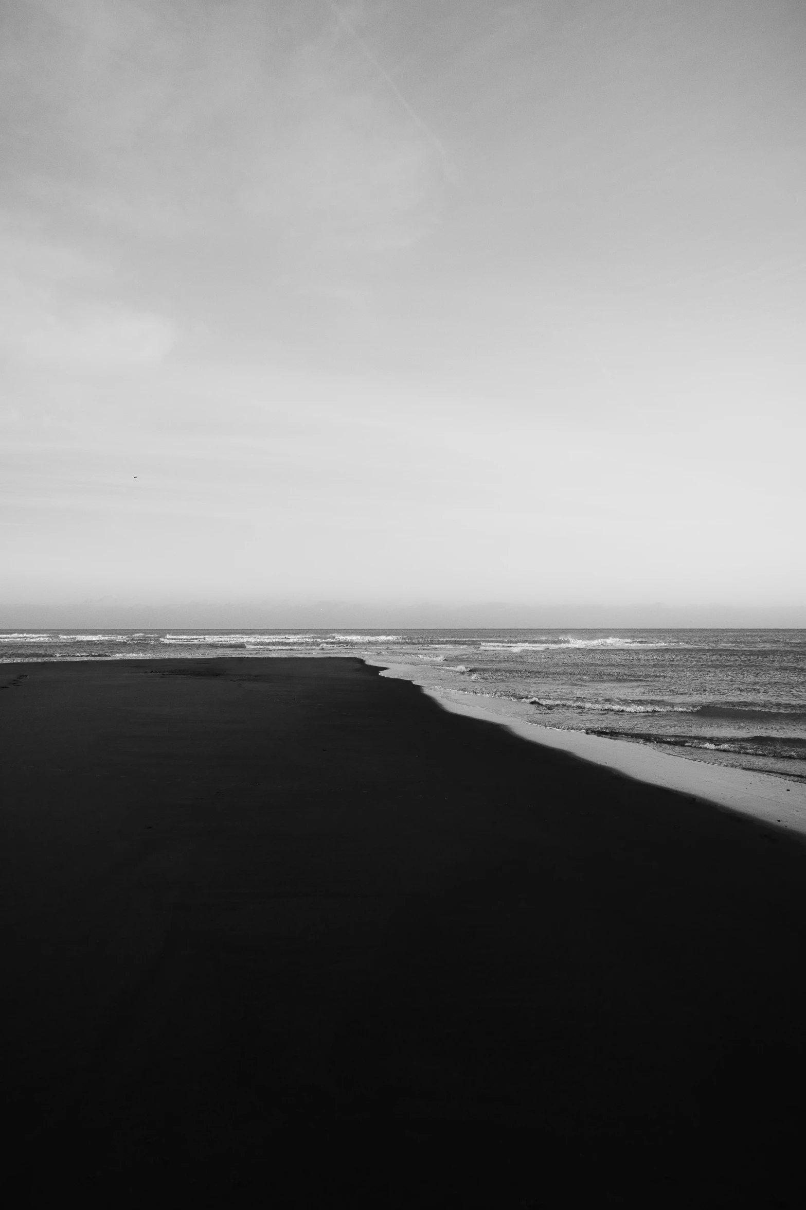 two surfers walk on the edge of an ocean line