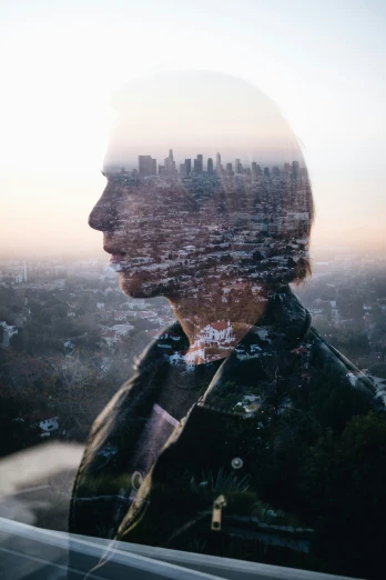 a double - exposure po of a city with a person in the window