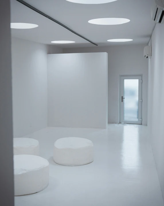 white room with two round shaped concrete stools