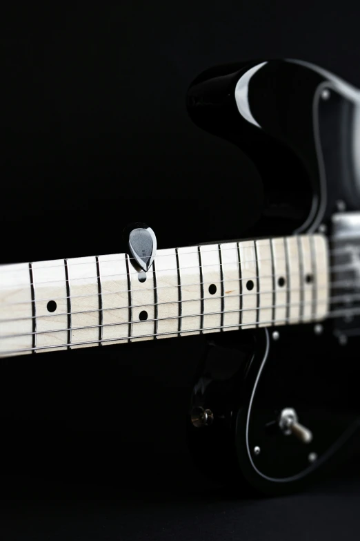 the neck and bridge of an electric guitar with black strings