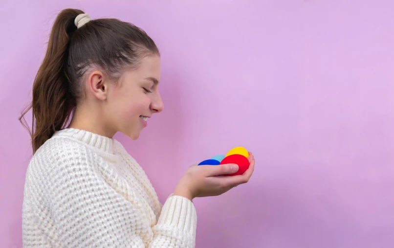 a girl with her eyes closed holds a small object