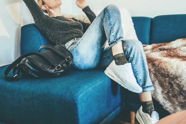 a young woman relaxes on a blue sofa