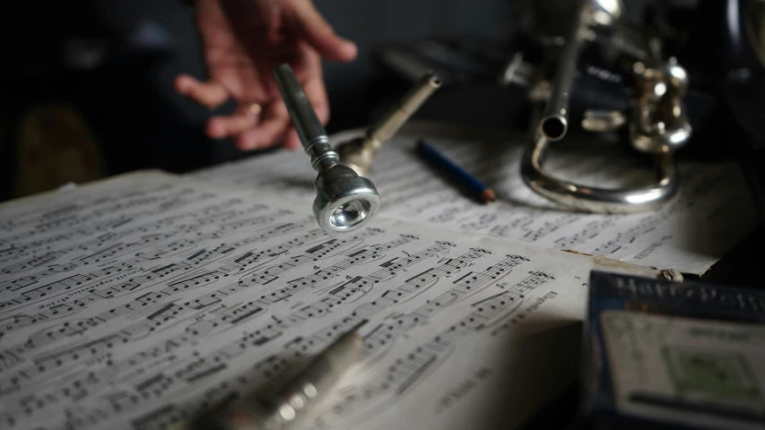 a person is holding some music notes next to a microscope