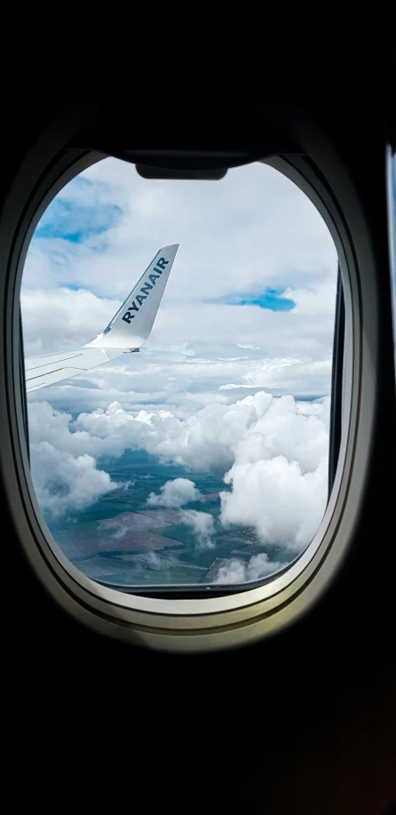 window in an airplane flying over the clouds