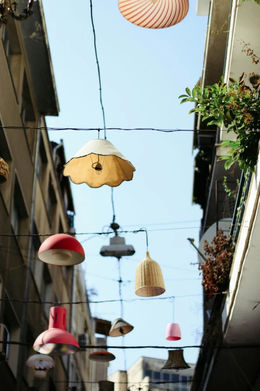 different lamps suspended from a building with string and wires