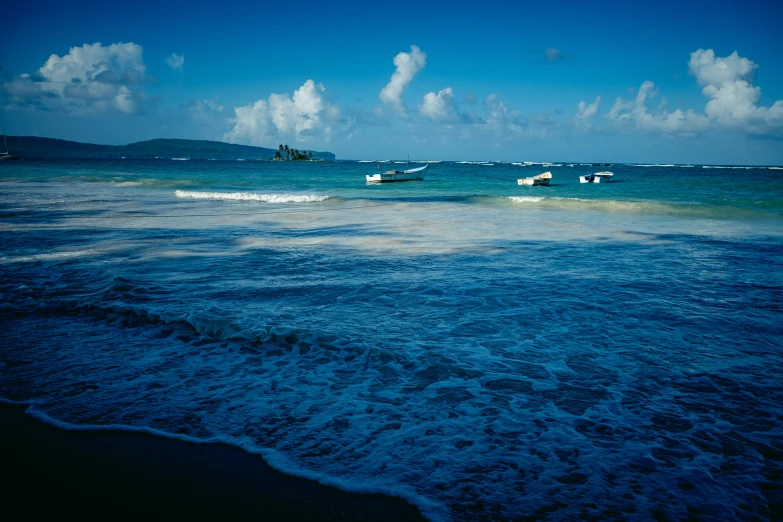 blue ocean water with boats out in the distance