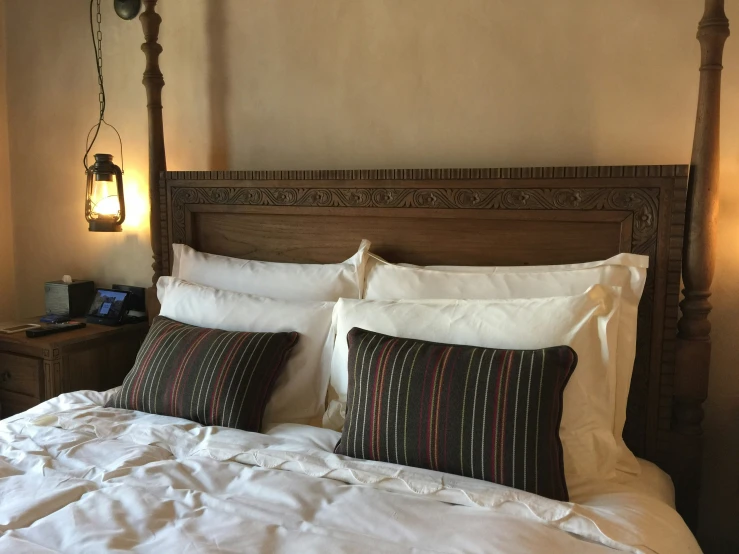 an ornate headboard, lamp, and bed in a bedroom