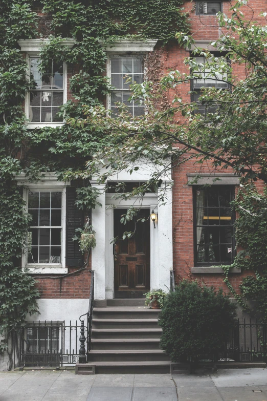 a brick building with a red door next to some stairs