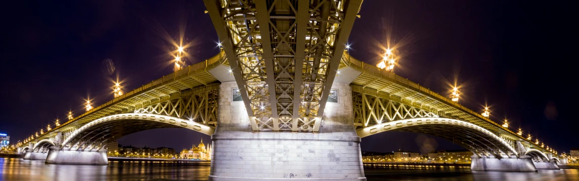 an old - fashioned image of an illuminated bridge over water