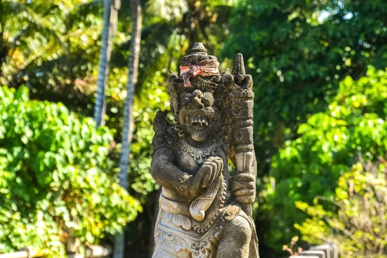 a statue stands beside a stone walkway