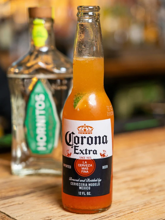 a close up of a bottle of orange juice on a wooden table