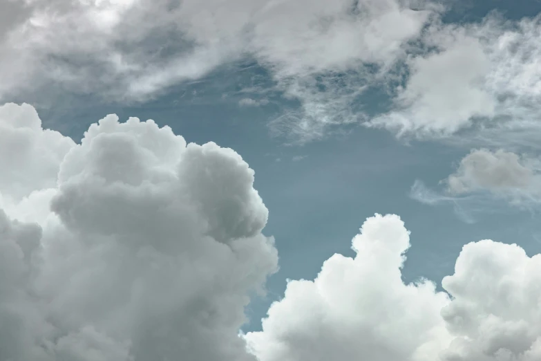 a very cloudy sky and a plane in the middle of it