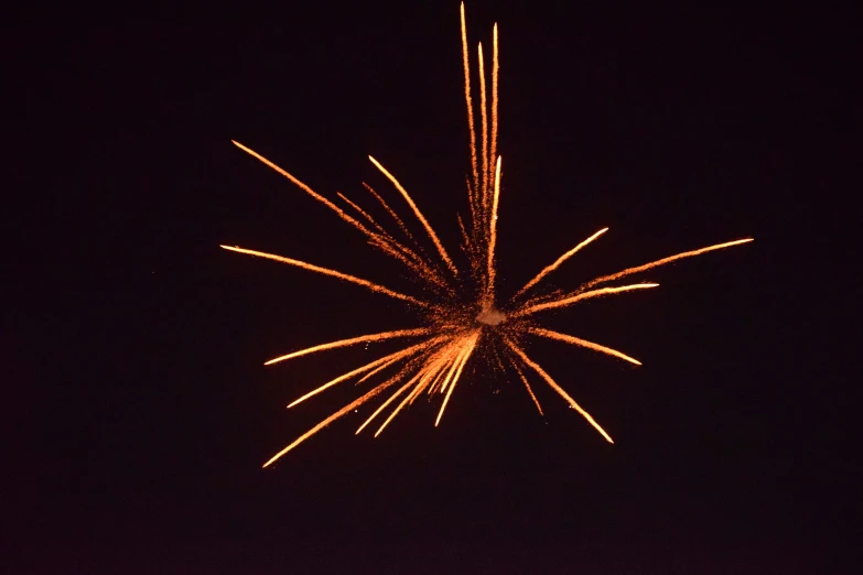 a small orange firework is in the sky