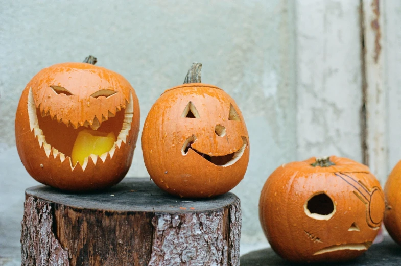 three pumpkins with faces carved on them, each with a different expression