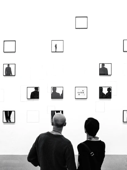 a couple standing in front of a wall of picture frames