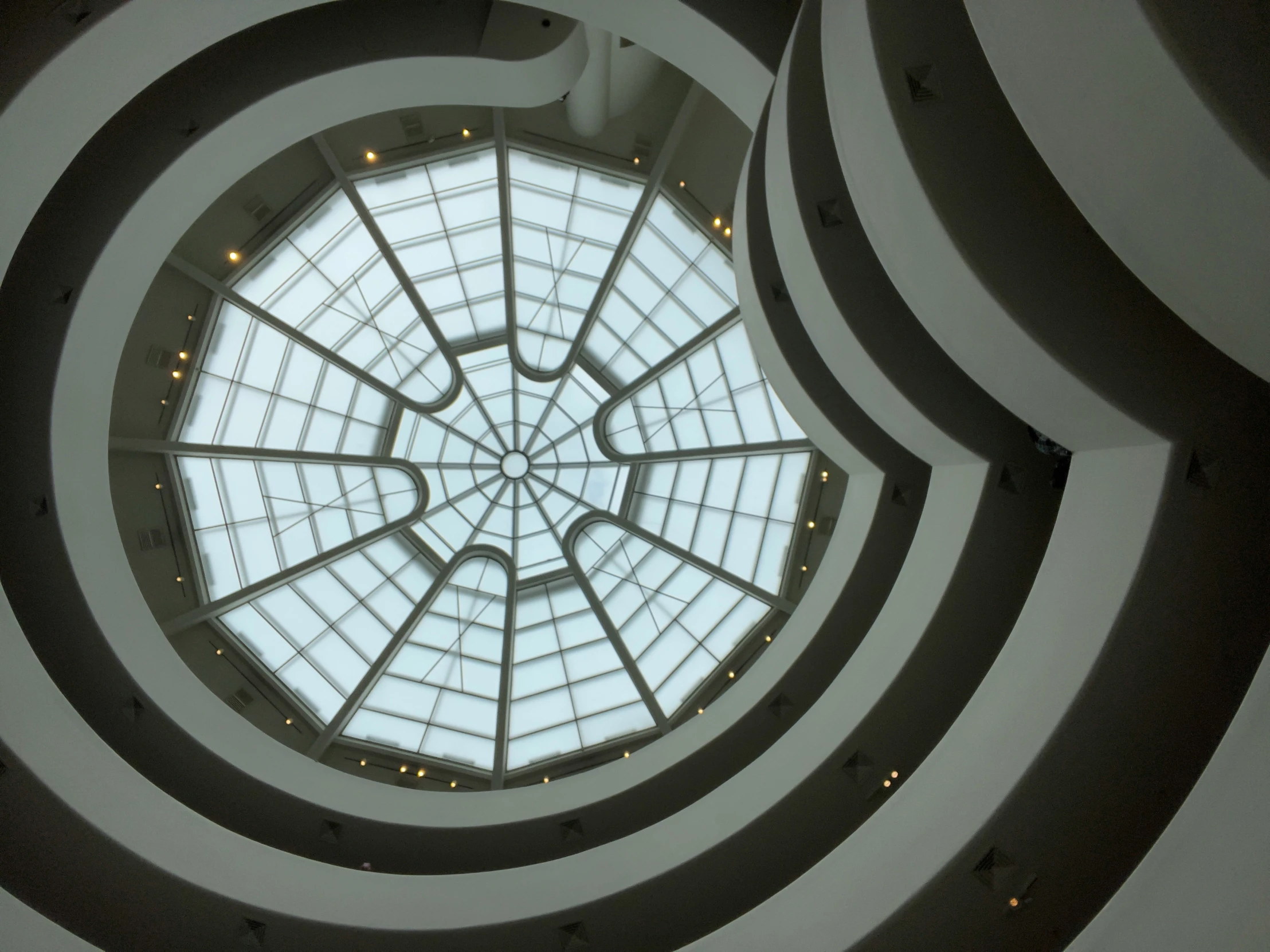 the interior view of a building looking up into a glass dome