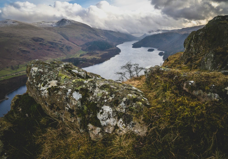 an overlook of mountains and lakes surrounded by moss